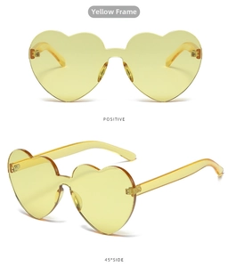 Front and 45-degree side views of translucent yellow heart-shaped rimless sunglasses
