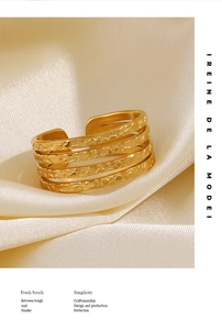 Macro detail of 18K gold plated multi-layer textured ring on elegant champagne silk fabric