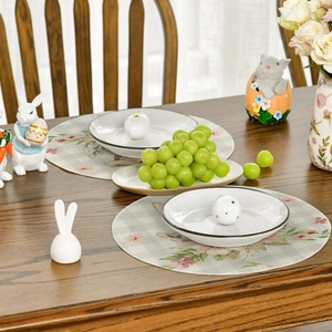 Easter round linen placemat with rabbit floral print on dark wooden dining table
