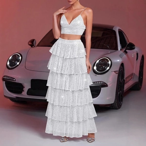 Detailed view of white sequined crop top and layered tiered maxi skirt with luxury car background