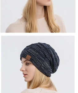 Detail of navy marl knit beanie with leather logo patch and model wearing view