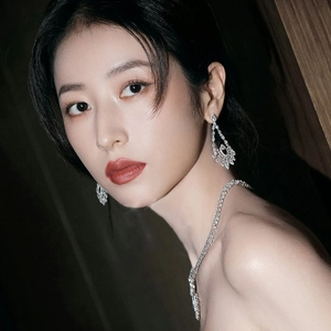 Close-up of model wearing luxury silver drop earrings with pear and marquise cut stones
