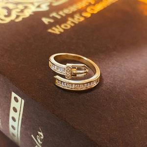 Macro view of gold-plated buckle ring with cubic zirconia on vintage book
