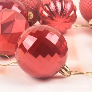 Macro detail of red Christmas baubles set featuring varied textures and gold hanging loops