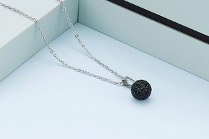 Detailed view of silver stainless steel chain with a black rhinestone paved ball pendant