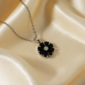 Collier élégant à fleur avec pétales noirs et chaîne argentée sur soie dorée