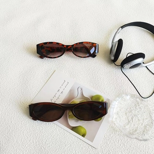 Vintage cat eye sunglasses in tortoiseshell and dark brown tones on white texture
