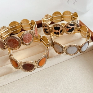 Detail showing elastic bracelets with leopard print and marble inlays on a velvet tray