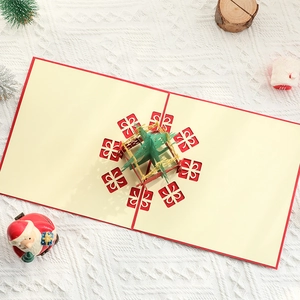 3D pop-up Christmas card featuring a green tree and red gift boxes on white knit background