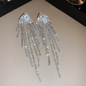 Macro shot of sparkling silver tassel earrings with micro-set rhinestones and luxury shine