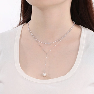 Detail of double-layer pearl necklace with elegant Y-shaped tassel and drop pearl pendant
