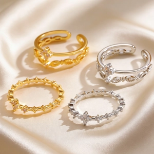 Macro shot of minimalist gold and silver multi-layer open rings on soft silk fabric