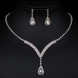 Detailed macro view of vintage silver necklace and teardrop rhinestone earrings set