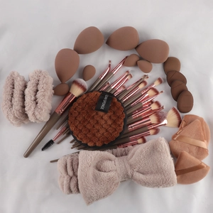 Macro shot of 40pc makeup set with brown brushes, sponges, and plush headbands