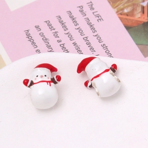 Détail macro de breloques bonhomme de neige en émail rouge et blanc pour bijoux DIY