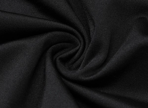 Macro shot of black knitted fabric with mesh texture and pleated detail on the T-shirt