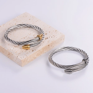 Detail of twisted cable stainless steel bracelets with conical ends on stone