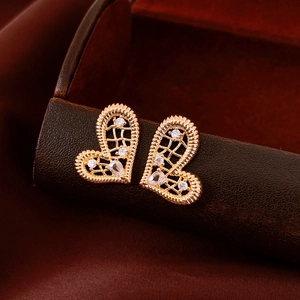 Vue macro de boucles d'oreilles cœur en plaqué or 18K serties de cristaux de zircone brillants