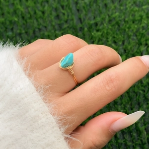 Detailed shot of handmade gold wire-wrapped ring with an irregular turquoise stone