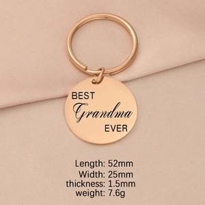 Detailed view of a rose gold keychain engraved with BEST Grandma EVER on pink fabric
