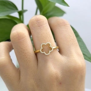 Macro shot of gold floral ring with sparkling zircon stones and delicate hollow petals
