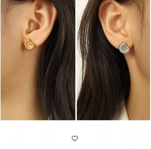 Macro detail of vintage spiral shell stud earrings in 18K gold and silver finishes