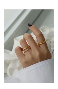 Macro shot of minimalist gold S925 silver rings with twisted horn and beaded textures
