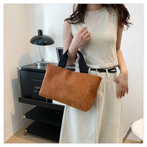 Texture détaillée du sac cabas en velours côtelé marron avec anses tissées