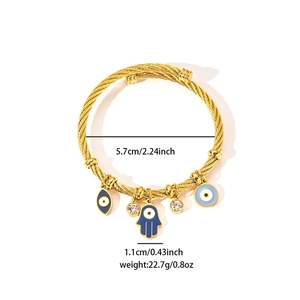 Detailed view of 18K gold-plated steel cable bracelet with Fatima hand and evil eye charms