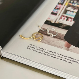 Artistic wavy 925 sterling silver rings in gold and silver finish on a fashion magazine