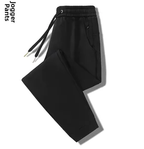 Detail of black joggers featuring elastic waistband with adjustable metal-tipped drawstrings