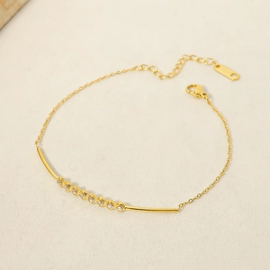 Close-up of 18k gold plated bracelet featuring curved rhinestone inlay and lobster clasp