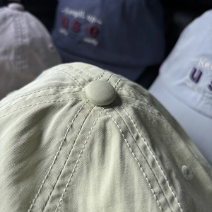 Macro shot of cotton baseball cap crown with stitched eyelets and premium fabric texture