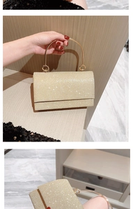 Detail van glitter avondtas met ronde metalen handvatten en glinsterende textuur