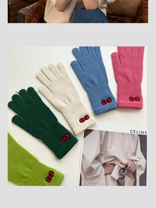 Flat lay of five colorful knitted gloves featuring red bow embroidery details on cuffs