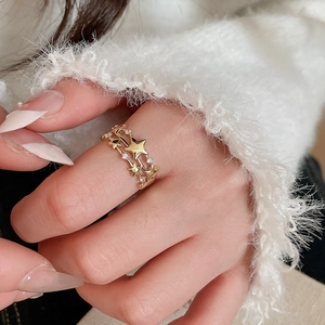 Macro shot of gold three-layer star ring with cubic zirconia worn by a model