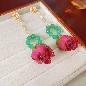 Details von roten Rosenknospen-Ohrringen mit grünen Perlen und Goldketten in Box