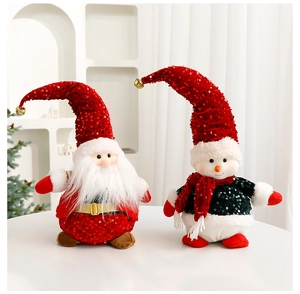 Detail of plush Santa and Snowman dolls with sequins and bells on a white tabletop
