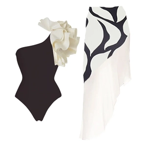 Detail of one-shoulder swimsuit with white ruffle and black leaf print asymmetrical skirt