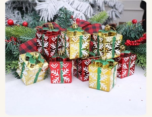 Detail of red and gold Christmas gift box ornaments with snowflake prints and glitter ribbons
