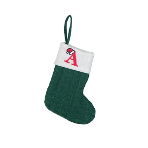 Green knitted Christmas stocking with red embroidered letter A on a white background