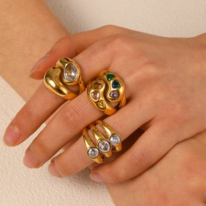 Chunky gold stainless steel rings with colorful heart shaped zircons worn on model hand