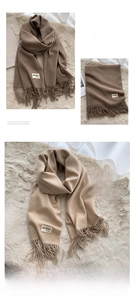 Detail of soft cashmere-like scarf showing fine fringe texture and branded label