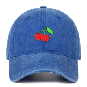 Detailed close-up of red cherry embroidery on vintage blue washed denim baseball cap