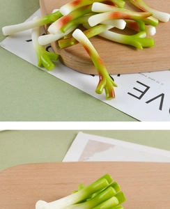 Detailed close-up of realistic faux scallion models on a wooden cutting board kitchen decor