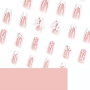 Pink press-on nails with 3D bows, white flowers and pearl accents for a cute French style