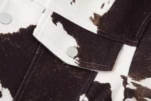 Macro view of animal print jacket fabric with flap pocket and silver metal snap button