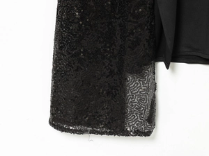 Detail of black sequin mesh fabric stitched with smooth premium material on a midi dress