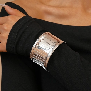 Detail of wide silver irregular cuff bracelet featuring layered wavy metal texture