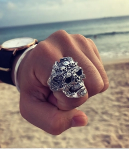 Gros plan d'une bague tête de mort punk vintage en finition argent vieilli portée à la main